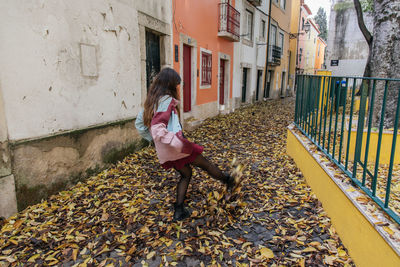 Full length of girl standing amidst buildings