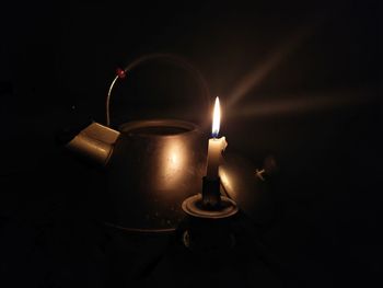 Close-up of illuminated tea light candles in darkroom