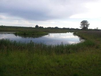 Scenic view of lake against cloudy sky