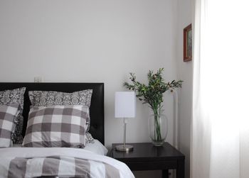 Lamp on table by bed at home