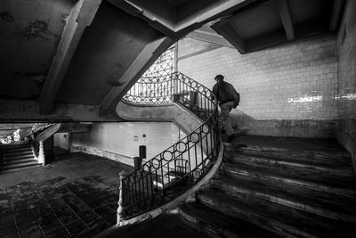 Rear view of man standing on staircase in building