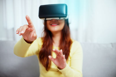 Young asian woman wearing virtual reality glasses, hand touching the air. vr headset. vr concept.