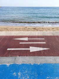 Text on beach by sea against sky