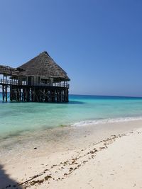 Scenic view of beach against clear blue sky