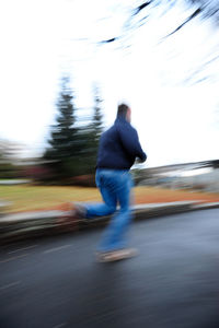 Side view of man running on road in city