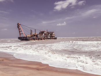 Ship on beach against sky