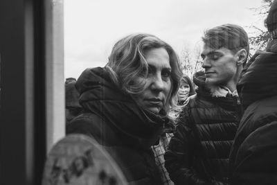 Portrait of young couple looking through window