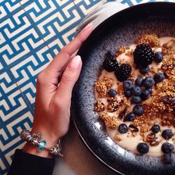 Cropped image of woman holding breakfast bowl at home