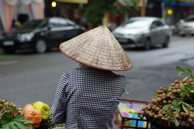 Rear view of person with umbrella on street in city