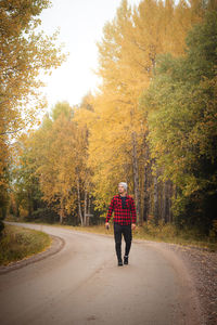 Man aged 23 wearing a checked red and black shirt walks along a foamy path. kainuu region, finland.