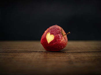 Close-up of apple on table against black background