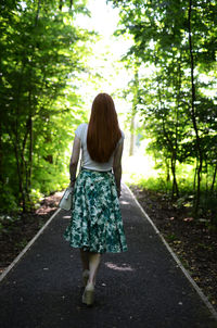 Rear view of woman walking on road