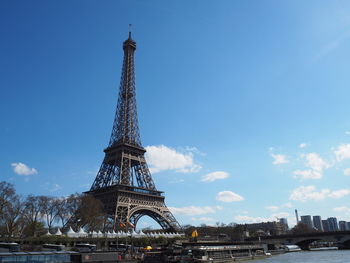 Communications tower in city against blue sky