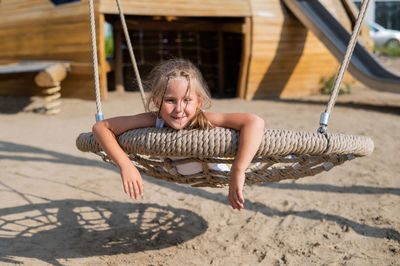 Portrait of boy sitting on swing