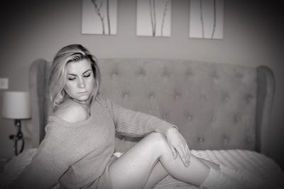 Young woman sitting on sofa at home