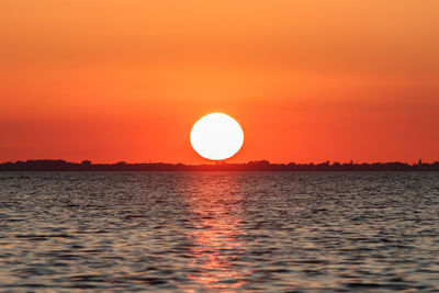 Scenic view of sea against romantic sky at sunset