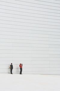 Close-up of two men against white wall