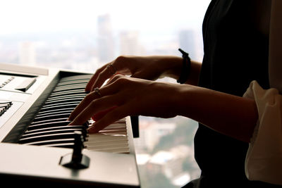 Close-up of midsection of woman playing synthesizer