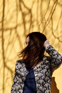 Rear view of woman standing against tree