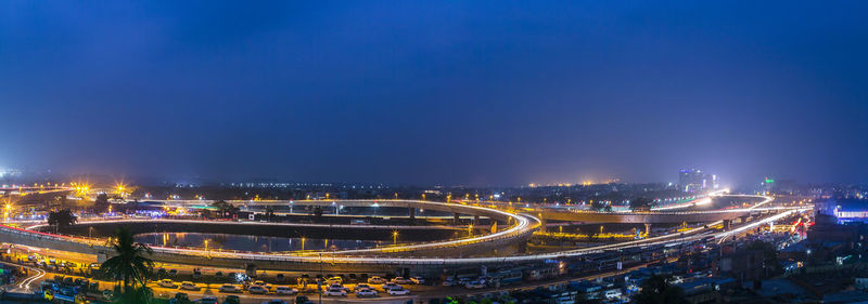 Panoramic shot of illuminated bridges against sky at night