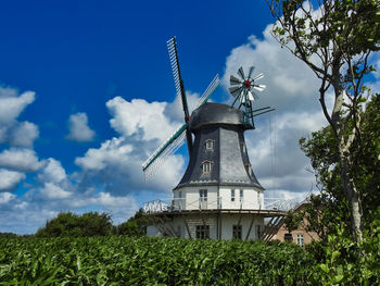 Traditional windmill on field against sky