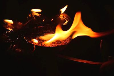 Close-up of lit candle in dark room