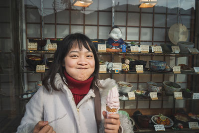 Portrait of woman making a face while holding ice cream in store