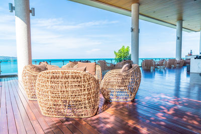 Panoramic shot of chairs by sea against sky