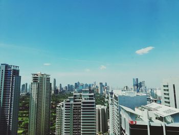 Modern buildings in city against blue sky