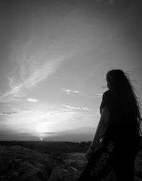 Side view of woman standing against sky