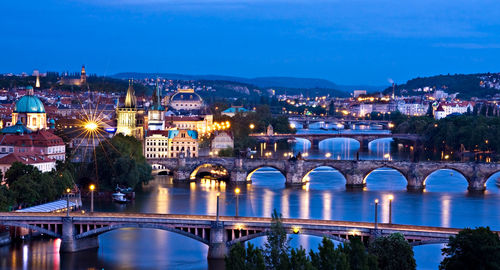 Illuminated bridge over river at night