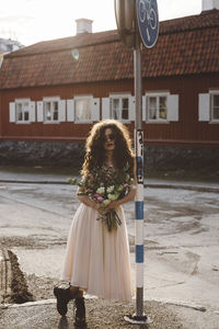 Woman standing near road sign