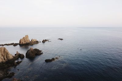 Scenic view of rocks in sea against sky