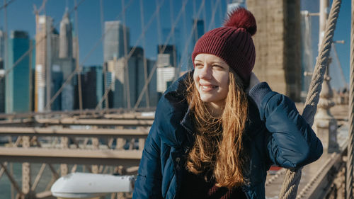 Portrait of smiling woman in city during winter