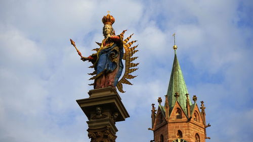Low angle view of statue of temple against cloudy sky