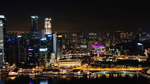 Illuminated buildings in city against sky at night