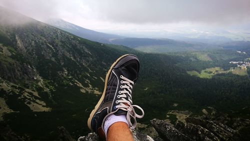 Low section of man standing on mountain road