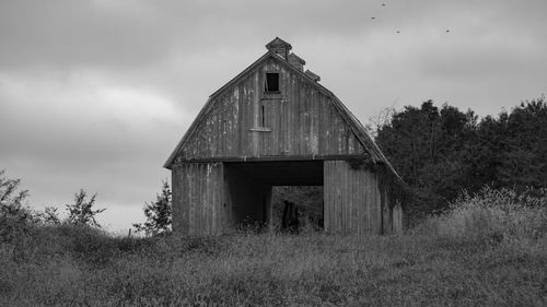 Abandoned house on field against sky