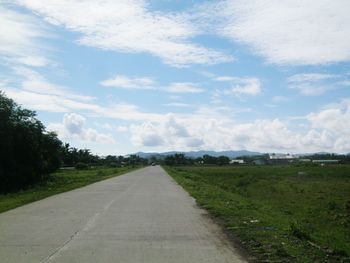 Empty road passing through field