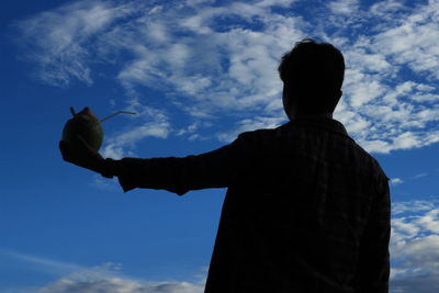 Silhouette man with coconut