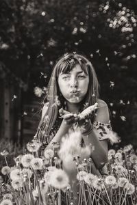 Portrait of girl holding plant on field