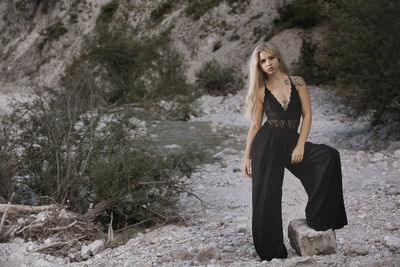 Portrait of beautiful young woman standing on stones