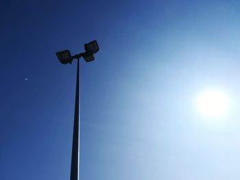 Low angle view of illuminated street light against clear blue sky