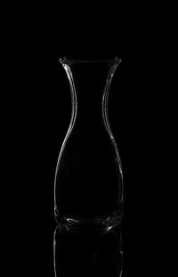 Close-up of empty glass bottle against black background