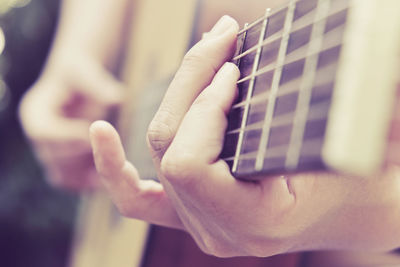 Close-up of hand playing guitar