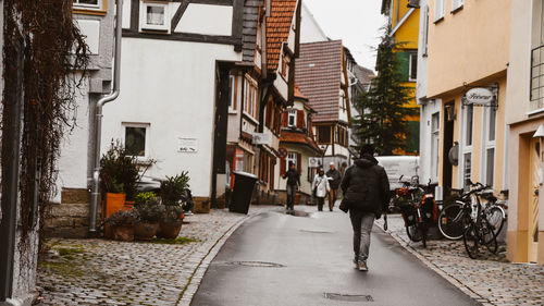 Rear view of man walking on street in city