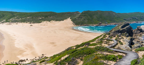 Scenic view of beach against clear blue sky