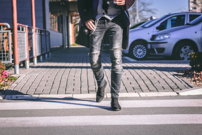 Low section of man walking on road