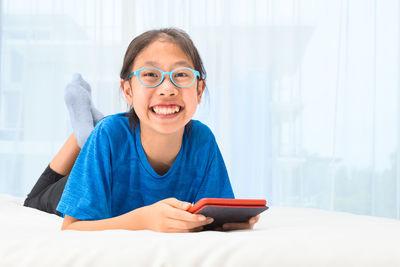 Portrait of smiling girl holding mobile phone