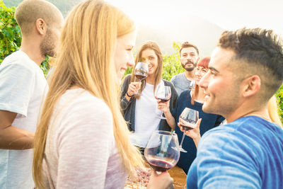 Friends with drinks standing outdoors